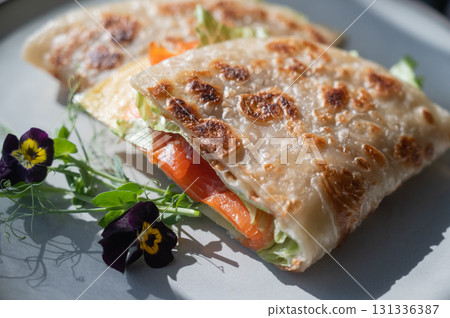 A flatbread stuffed with fish and cheese served in a cafe. Quesadilla. A flatbread stuffed with fish and cheese served in a cafe. Quesadilla. 131336387