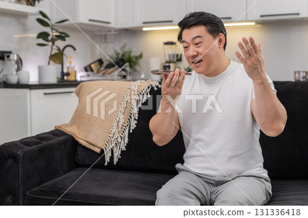 Asian man argues on smartphone frowns shows no no finger gesture speaks firmly and rejects request Asian man argues on smartphone frowns shows no no finger gesture speaks firmly and rejects request 131336418