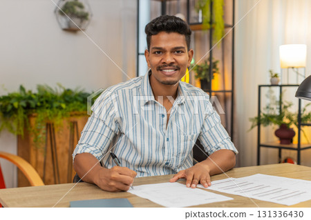 Indian man finds correct contract signs with pen smiles confident about decision result success win Indian man finds correct contract signs with pen smiles confident about decision result success win 131336430