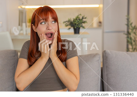 Young woman grabs cheeks and shouts wow happily surprised by good news joyful reaction big smile yay Young woman grabs cheeks and shouts wow happily surprised by good news joyful reaction big smile yay 131336440