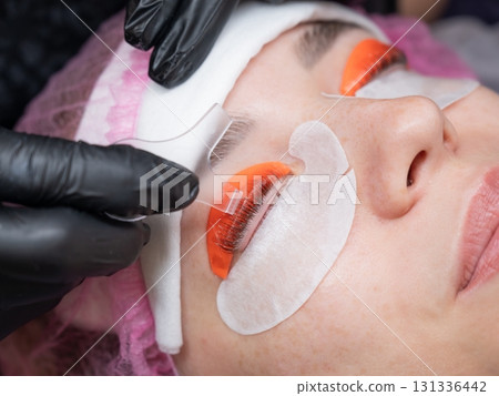 Caucasian woman undergoing eyelash lamination procedure.  131336442