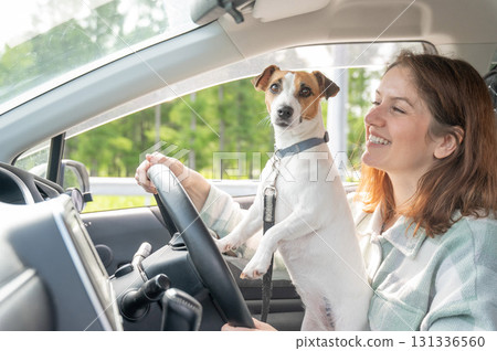 Caucasian woman traveling by car with her dog. Caucasian woman traveling by car with her dog. 131336560