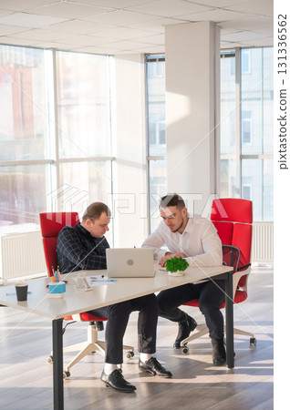 Two Caucasian men chatting in an office. Two Caucasian men chatting in an office. 131336562