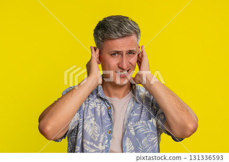 Adult man covering ears and shaking head with denial refusing to hear anything with strong rejection 131336593
