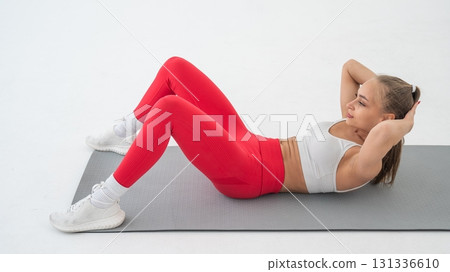 Young woman doing abdominal exercises on white background. 131336610