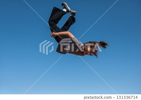 A girl jumps on an outdoor trampoline. A girl jumps on an outdoor trampoline. 131336714