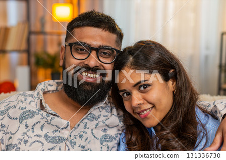 Indian family couple man woman holding hands sit in silence at home, sharing peaceful emotional bond Indian family couple man woman holding hands sit in silence at home, sharing peaceful emotional bond 131336730