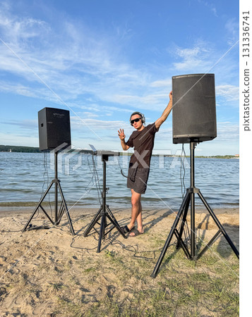 Male DJ playing music on the beach.  131336741