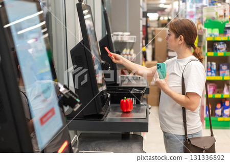 Woman paying with credit card at self-checkout. Woman paying with credit card at self-checkout. 131336892