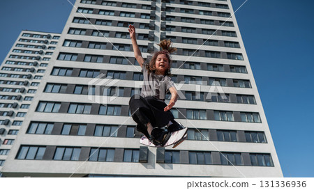 Girl practices skiing tricks on a trampoline.  131336936