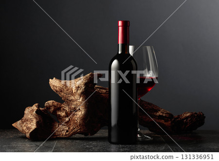 Red wine and old weathered snag on a black stone table. Red wine and old weathered snag on a black stone table. 131336951