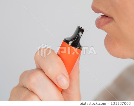 Caucasian woman smoking disposable vape. Caucasian woman smoking disposable vape. 131337003