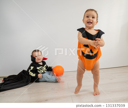 Cute kids celebrate halloween on white background. Two little boys in dracula costume and pumpkin. Cute kids celebrate halloween on white background. Two little boys in dracula costume and pumpkin. 131337039