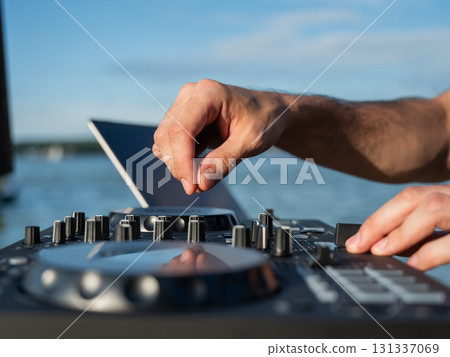 Close up of DJ's hands while working outdoors.  131337069