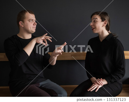 A man and a woman are talking in Russian sign language. A man and a woman are talking in Russian sign language. 131337123