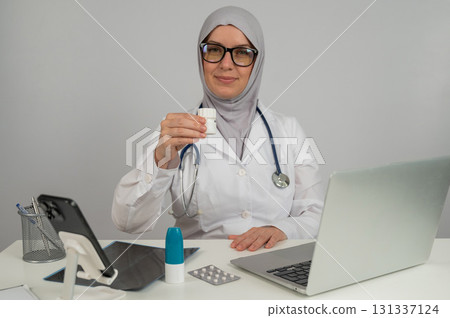 Female doctor in hijab recommends medications. Female doctor in hijab recommends medications. 131337124