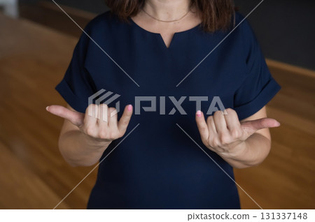 A woman shows the word today in Russian sign language. A woman shows the word today in Russian sign language. 131337148