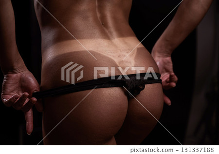 A faceless woman in black panties shows off the result of an instant tan 131337188