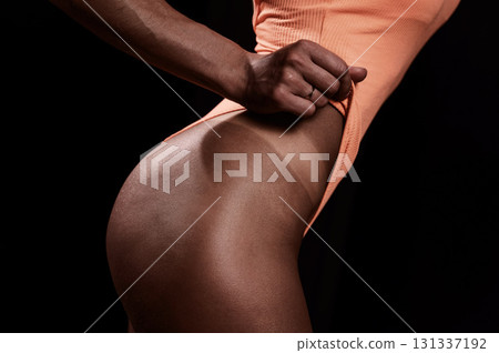 A faceless woman in an orange swimsuit demonstrates the result of an instant tan A faceless woman in an orange swimsuit demonstrates the result of an instant tan 131337192