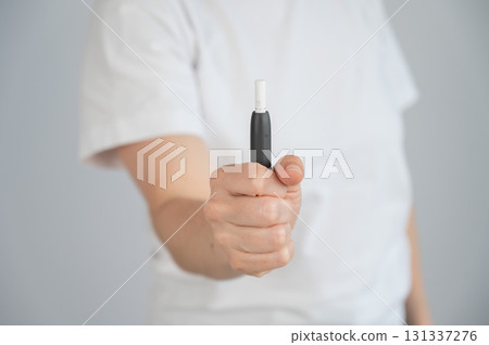 Faceless woman holding tobacco heating system.  131337276