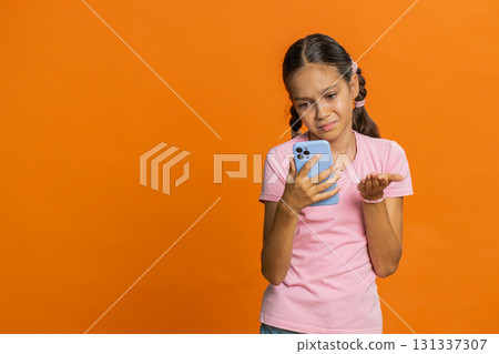 Upset sad child girl use smartphone play game loses loss fail unlucky news bad lottery result crisis Upset sad child girl use smartphone play game loses loss fail unlucky news bad lottery result crisis 131337307