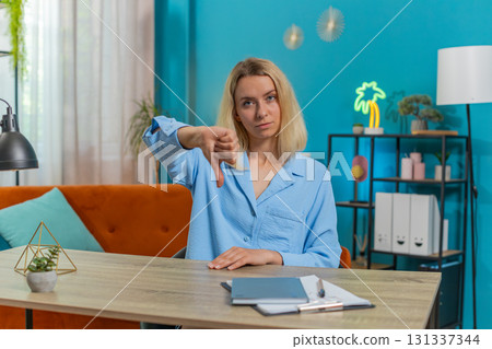 Upset businesswoman showing thumbs down dislike sign gesture, expressing discontent, disapproval Upset businesswoman showing thumbs down dislike sign gesture, expressing discontent, disapproval 131337344