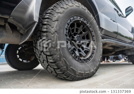 Close-Up of a Rugged Off-Road Tire on a Black SUV. Close-Up of a Rugged Off-Road Tire on a Black SUV. 131337369