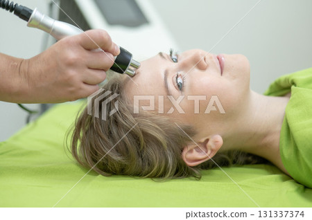 Caucasian woman undergoing radio wave RF lifting procedure in beauty salon.  131337374