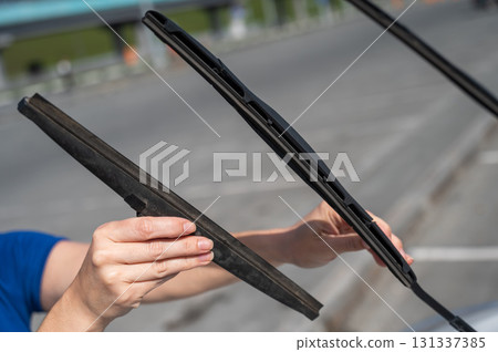 Close up of female hands changing windshield wipers.  131337385
