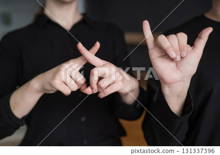 A man and a woman show the phrase technical university in sign language. A man and a woman show the phrase technical university in sign language. 131337396