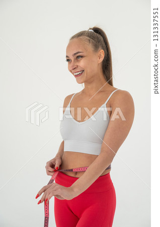 Young woman measuring her waist on white background. 131337551