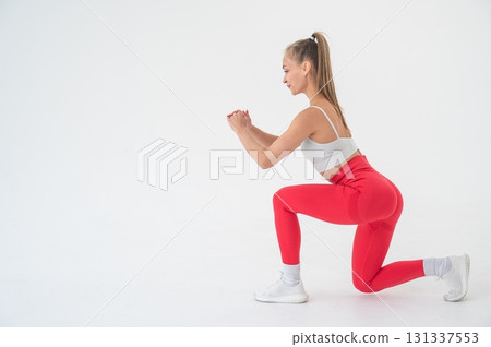 Young woman doing lunges on white cyclorama background. Vertical video.  131337553