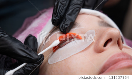 Caucasian woman undergoing eyelash lamination procedure.  131337564