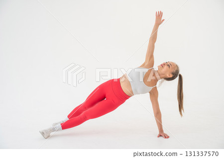 Young woman doing side plank on white background. Young woman doing side plank on white background. 131337570