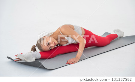 Young woman doing splits exercises on white background. 131337592