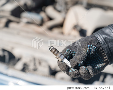 Caucasian man changing spark plugs in car.  131337651
