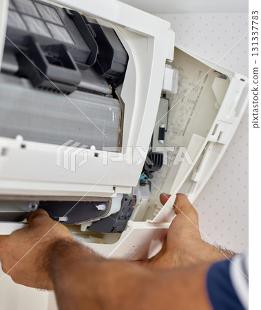 male hand of worker from the cleaning service cleans the air conditioner , close-up 131337783