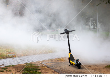A yellow and black scooter is enveloped by a thick cloud of smoke A yellow and black scooter is enveloped by a thick cloud of smoke 131338165