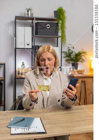 Angry mad stressed businesswoman trying to pay online shopping with blocked credit card smartphone 131338188