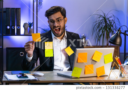 Tired sad exhausted businessman working on laptop at office with many sticker tasks, panic attack 131338277