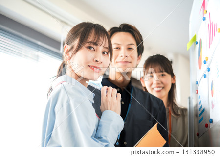 Three men and women having a meeting using a whiteboard Three men and women having a meeting using a whiteboard 131338950