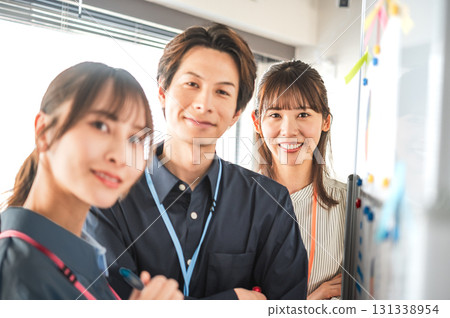 Three men and women having a meeting using a whiteboard 131338954