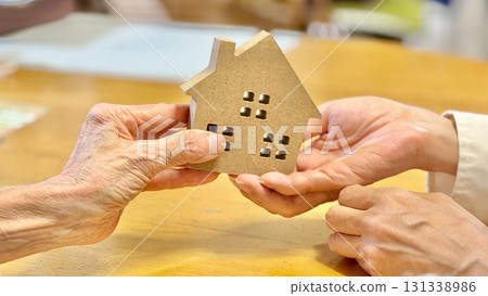 老年婦女將家居用品遞給另一位婦女_表格背景 老年婦女將家居用品遞給另一位婦女_表格背景 131338986