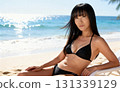 一位身穿泳衣的中年婦女在海灘上放鬆的肖像 131339129