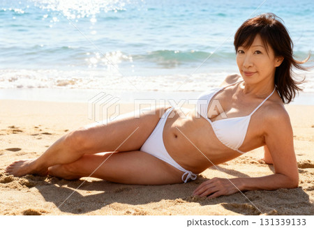 一位身穿泳衣的中年婦女在海灘上放鬆的肖像 131339133