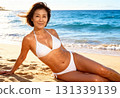 一位身穿泳衣的中年婦女在海灘上放鬆的肖像 131339139