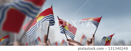 Kiribati flags in their hands on a blurred urban background 131340249