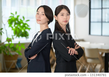 Japanese women standing in a row in the office, arms crossed, looking at the camera 131340781