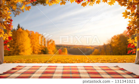 Cozy blanket on grass under colorful autumn trees at sunset 131341021