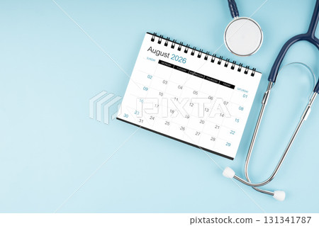 August 2026 desk calendar and stethoscope on blue color, Position with copy space. August 2026 desk calendar and stethoscope on blue color, Position with copy space. 131341787